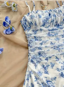 Dettaglio di un abito francese a fiori blu con delicati volant arricciati ed eleganti.