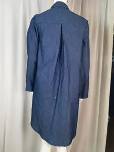 Vista posteriore di un abito midi in denim blu scuro a maniche lunghe con pieghe.