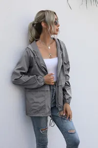Detailed look at women's lightweight grey hooded rain jacket for outdoor hiking adventures