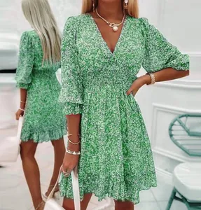 Detail view of green floral chiffon dress featuring V-neck and ruffled hem design