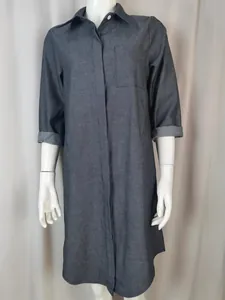 Vista dettagliata di un abito a camicia in denim grigio scuro su un manichino con colletto.