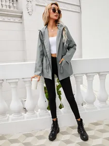 Modella indossa una giacca a vento grigia impermeabile con coulisse in vita
