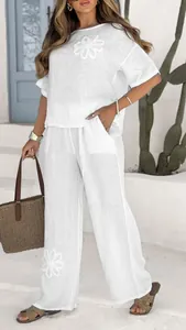 Full detail of white 2-piece linen set featuring elegant floral embroidery and wide leg pants