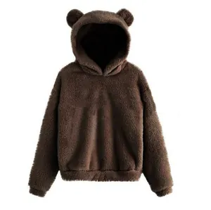 Close-up van een bruine pluizige hoodie met berenoren van zachte fleece en pluche textuur