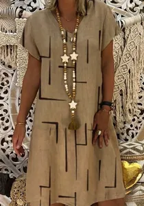 Detail of women's khaki V-neck summer dress with black geometric print and linen texture.
