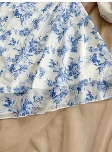 Primo piano della stampa floreale blu su chiffon bianco che mostra drappeggio e texture