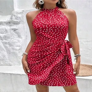 Dettaglio di un vestito corto rosso allacciato al collo con pois bianchi e fiocco lato.