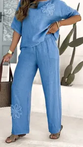 Close-up view of a blue embroidered linen two-piece set featuring high waist wide leg pants