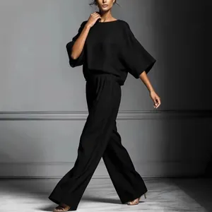 Elegant black two-piece linen set featuring bell sleeve top and wide-leg trousers