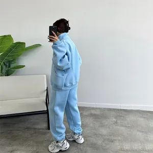 Side view of woman in light blue loose fleece-lined sweatshirt and sweatpants set
