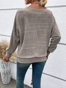 Detailed macro view of beige ribbed knit long-sleeve top showing center back seam
