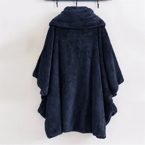 Vista posteriore di un poncho in pile peluche blu navy appeso ai ganci
