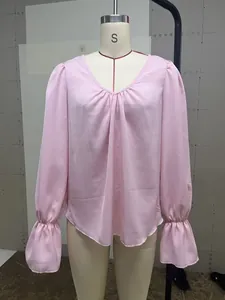Detailed macro view of pink V-neck pleated long sleeve blouse on a mannequin