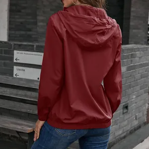 Rückansicht einer bordeauxroten wasserdichten Damen-Windjacke mit Kapuze für draußen