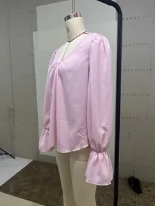 Side profile of elegant pink V-neck pleated satin blouse featuring ruffled puff sleeves
