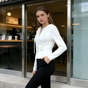 Detailed shot of a women's white slim fit ribbed zip-up hoodie in a casual setting