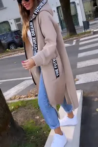 Stijlvolle lifestyle-weergave van een lange beige fleecejas met capuchon voor dames met lint