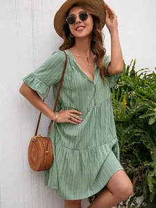 Detail of the ruffled sleeves and textured fabric on the green V-neck casual dress