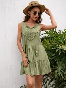 Detalle del vestido de verano sin mangas verde salvia con cuello en V de encaje y borlas
