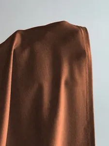 Vue détaillée du tissu marron uni montrant la texture de l'ourlet avec sa double surpiqûre.