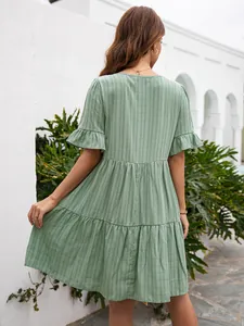 Detailed back view of a sage green tiered mid-length casual dress with ruffle cuffs.
