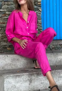 Ensemble deux pièces chemise et pantalon en lin rose vif présenté en extérieur décontracté.