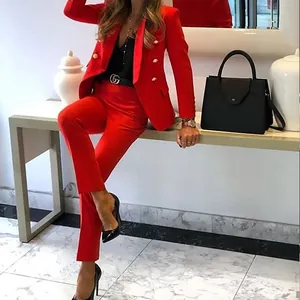Detailed view of elegant women's bright red tailored two-piece blazer and trouser suit