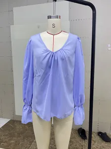 Front view of an elegant loose V-neck pleated lavender blouse displayed on a mannequin.