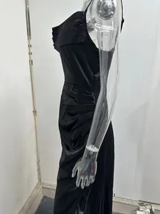 Side view of black satin evening dress with elegant pleated details and high side slit.