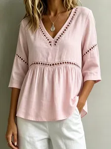 Nahaufnahme-Detail einer rosa V-Ausschnitt Bluse aus Baumwollleinen mit Lochspitze