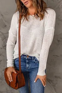 Detailed shot of a white long-sleeved knit sweater with elegant semi-sheer texture.