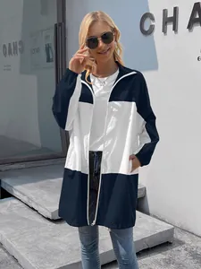 Detail view of a women's navy and white color-block hooded waterproof windbreaker jacket