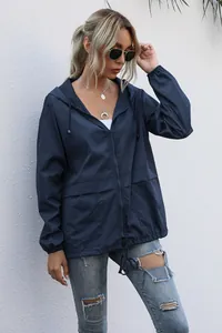 Details of navy blue lightweight zip-up hooded jacket worn by model for hiking