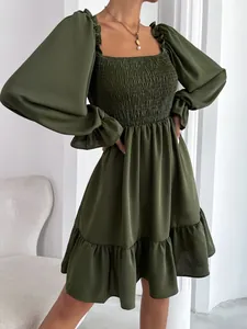 Detail van een olijfgroene jurk met vierkante hals en gesmokt lijfje met ruches