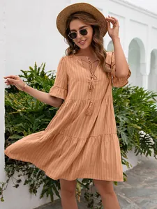 Elegant apricot V-neck tiered mini dress featuring tassel details and ruffly sleeves