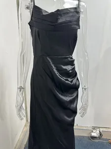 Close-up of black satin dress showing pleated bodice and ruched skirt details