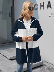 Detail view of a navy and white color-block hooded waterproof windbreaker on a model