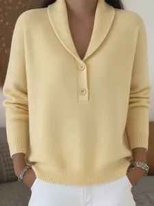 Détail d'un pull en maille jaune pâle avec un col châle élégant et des boutons