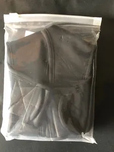 Adjustable black back posture corrector neatly folded in a clear zipper storage bag.