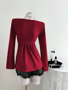 Vue arrière d'un haut élégant à manches longues rouge avec détails plissés pour femmes
