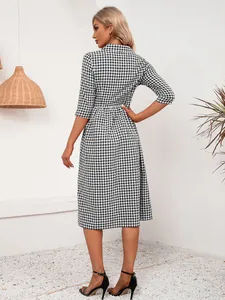Vista trasera de un vestido camisero midi casual de cuadros vichy blancos y negros
