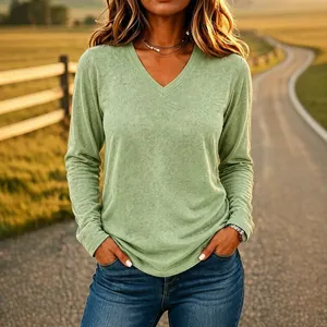 Women's sage green casual V-neck loose long-sleeve T-shirt shown in sunset light