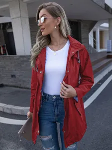 Close-up view of a stylish red women's hooded windbreaker raincoat in an urban setting