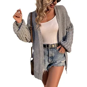 Detail of gray knit cardigan featuring textured lantern sleeves and open front design.