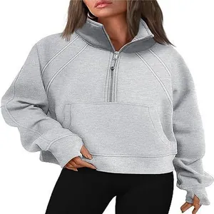Close-up detail of women's light gray half-zip cropped sweatshirt with stand collar