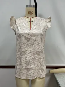 Detail view of champagne satin blouse with ruffle sleeves and floral pattern
