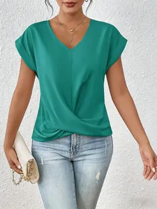 Detail showing the elegant green V-neck top with a stylish front twist hem and soft texture