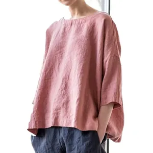 Détail d'une blouse rose en lin surdimensionnée à col rond et tissu texturé de coton