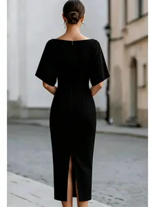 Elegante abito midi nero con spacco posteriore e maniche corte in ambientazione urbana