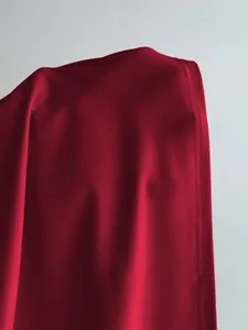 Vue rapprochée de la texture en maille rouge douce et des coutures du haut pour femme.
